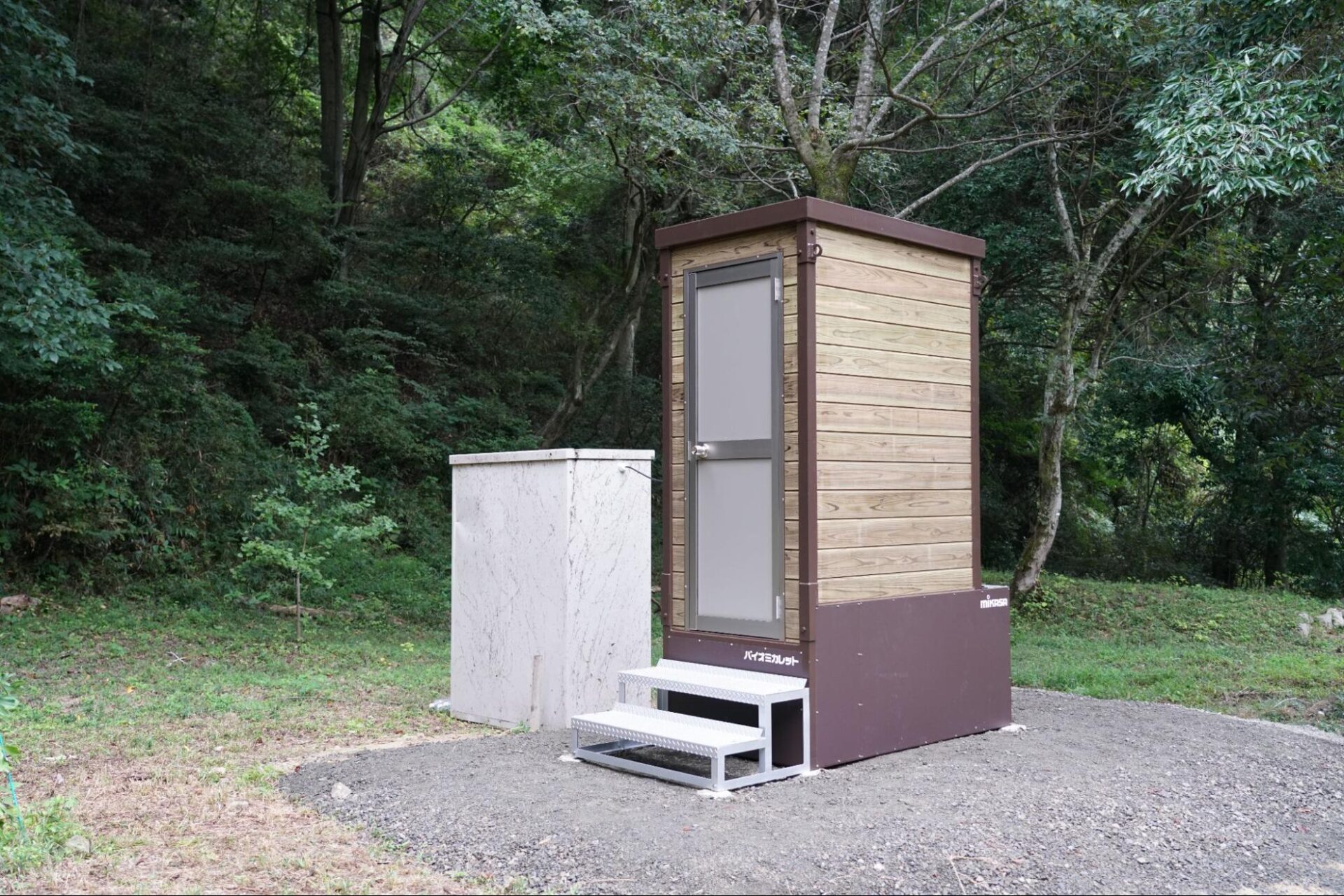 山中に新設された木目調のバイオトイレと隣接する発電機収納ボックス