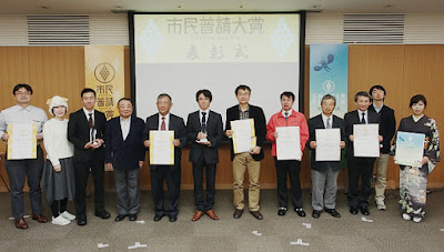 市民普請大賞の表彰式で賞状やトロフィーを手に記念撮影する関係者たち