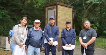 完成したバイオトイレの前で記念撮影をする市民団体・行政・企業関係者